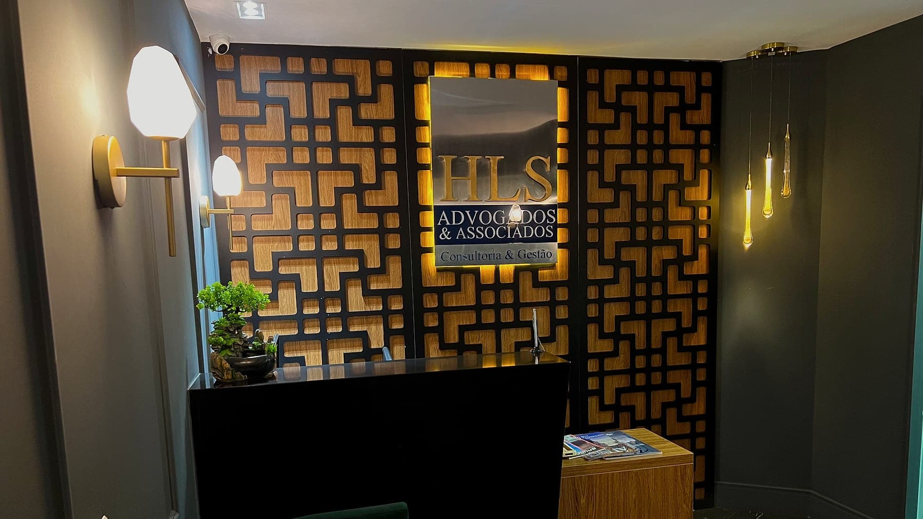 Recepção do escritório, com a placa da banca sobre o painel de madeira
